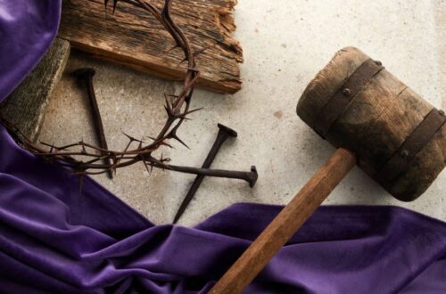 purple robe, nails, crown of thorns shown on a table; the crucifixion of Christ