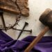 purple robe, nails, crown of thorns shown on a table; the crucifixion of Christ