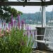 view of white porch swing with purple and pink flowers in the foreground and a lake in the background; overcoming writer's block